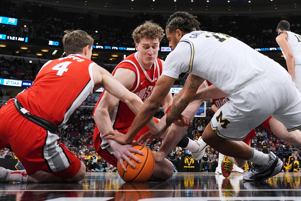 Ohio State center Christoph Tilly, center, battles for a loose ball against guard Gabe Cupps, left, and Michigan guard Roddy Gayle Jr. during the first half of an NCAA college basketball game in the quarterfinals of the Big 10 Conference tournament, Friday, March 13, 2026, in Chicago. (AP Photo/Nam Y. Huh)