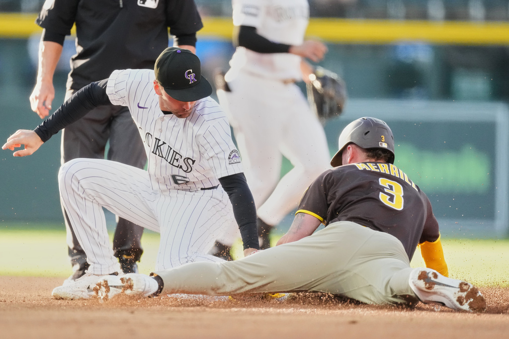 Colorado Rockies second baseman Edouard Julien, left, applies a late tag to San Diego Padres' Jackson Merrill as he steals second basein the first inning of a baseball game Wednesday, April 22, 2026, in Denver. (AP Photo/David Zalubowski)
