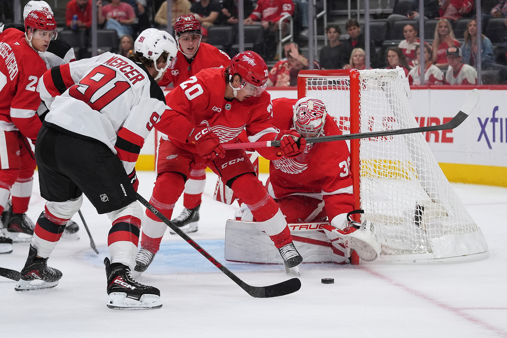 Detroit Red Wings goaltender John Gibson (36) stops a New Jersey Devils center Dawson Mercer (91) shot as Albert Johansson (20) defends in the first period of an NHL hockey game Tuesday, Oct. 13, 2026, in Detroit. (AP Photo/Paul Sancya)
