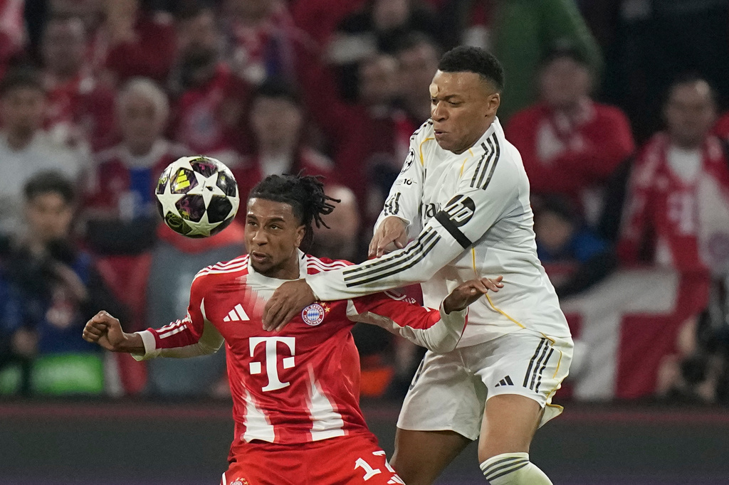 Bayern's Michael Olise, left, challenges for the ball with Real Madrid's Kylian Mbappe during the Champions League quarterfinal second leg soccer match between Bayern Munich and Real Madrid in Munich, Germany, Wednesday, April 15, 2026. (AP Photo/Matthias Schrader)