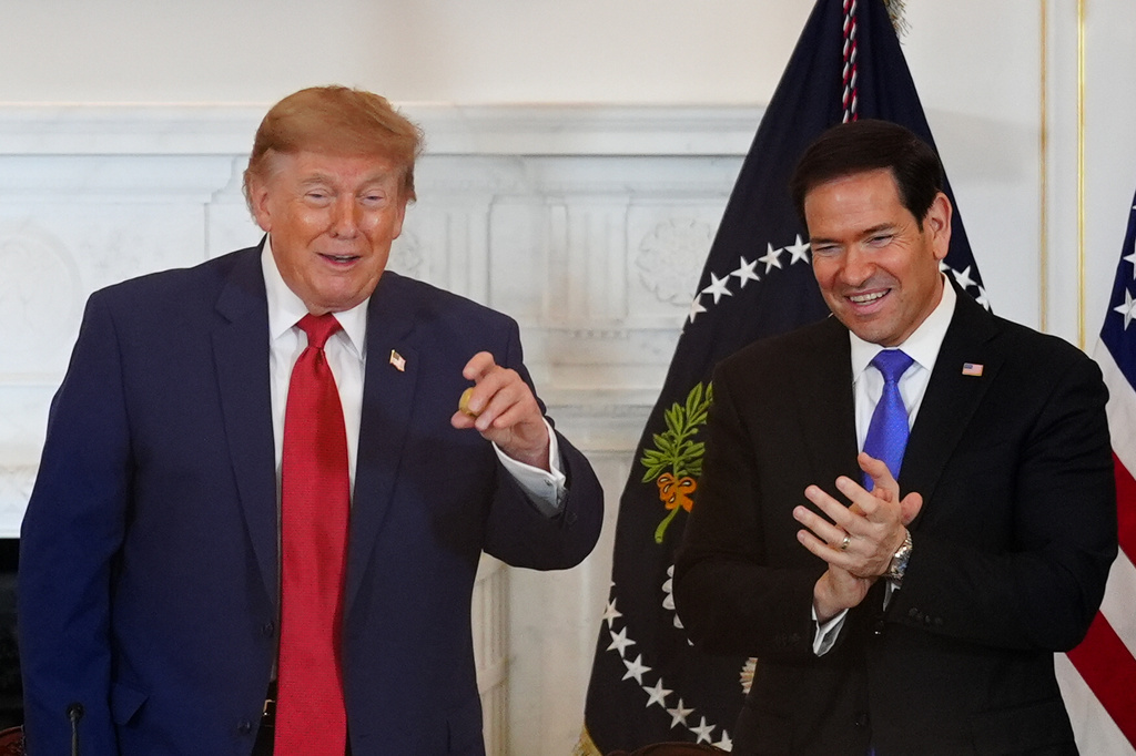 President Donald Trump holds a gold nugget he was presented as Secretary of State Marco Rubio watches during a roundtable on the American mining industry, Friday, Aug. 7, 2026, at the State Department in Washington. (AP Photo/Julia Demaree Nikhinson)