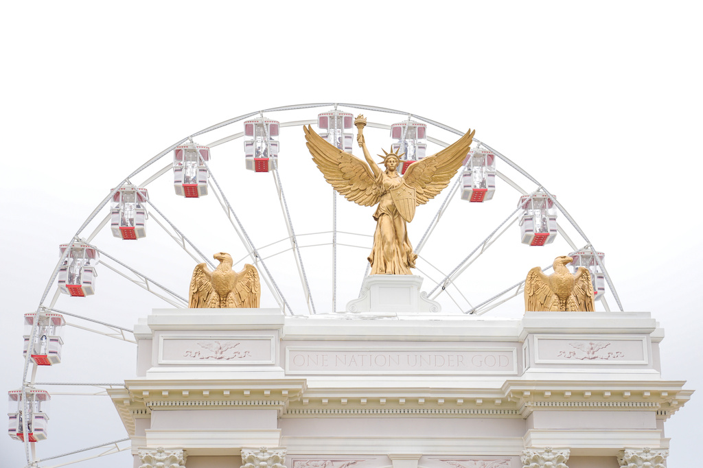 A model of the proposed triumphal arch, and the ferris wheel are seen at the Great American State Fair on the National Mall, Tuesday, July 7, 2026, in Washington. (AP Photo/Mariam Zuhaib)