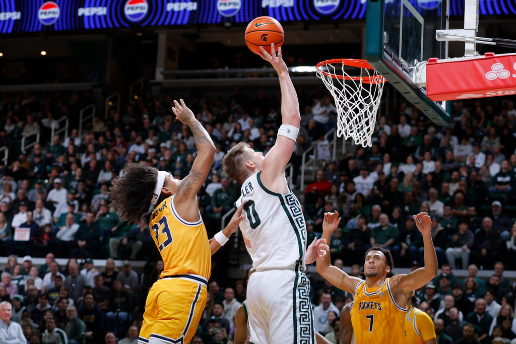 Michigan State forward Jaxon Kohler (0) shoots against Toledo guard Phoenix Glassnor (23), left, and forward Sean Craig (7) during the first half of an NCAA college basketball game, Tuesday, Dec. 16, 2025, in East Lansing, Mich. (AP Photo/Al Goldis)