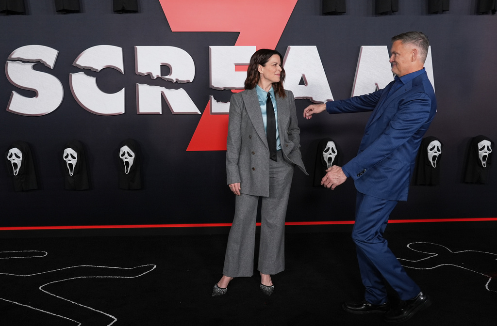 Neve Campbell, left, a cast member in "Scream 7," is greeted by the film's director/co-writer Kevin Williamson at the premiere of the film on Wednesday, Feb. 25, 2026, at Paramount Studios in Los Angeles. (AP Photo/Chris Pizzello)