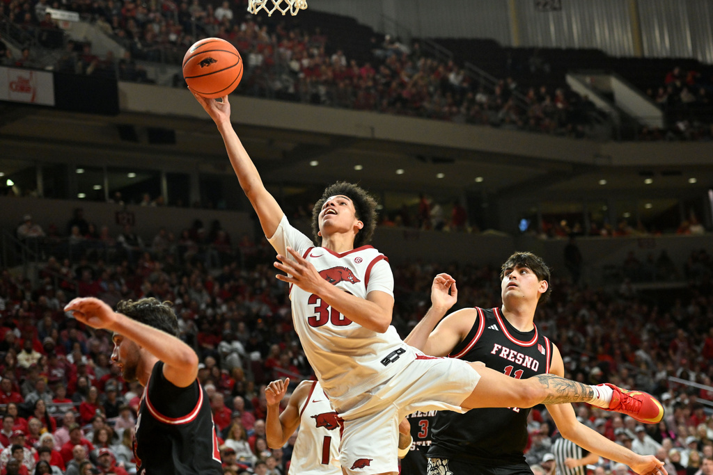 Arkansas guard Isaiah Sealy (30) drives past Fresno State forward Jac Mani (11) to score during the second half of an NCAA college basketball game Saturday, Dec. 6, 2025, in North Little Rock, Ark. (AP Photo/Michael Woods)