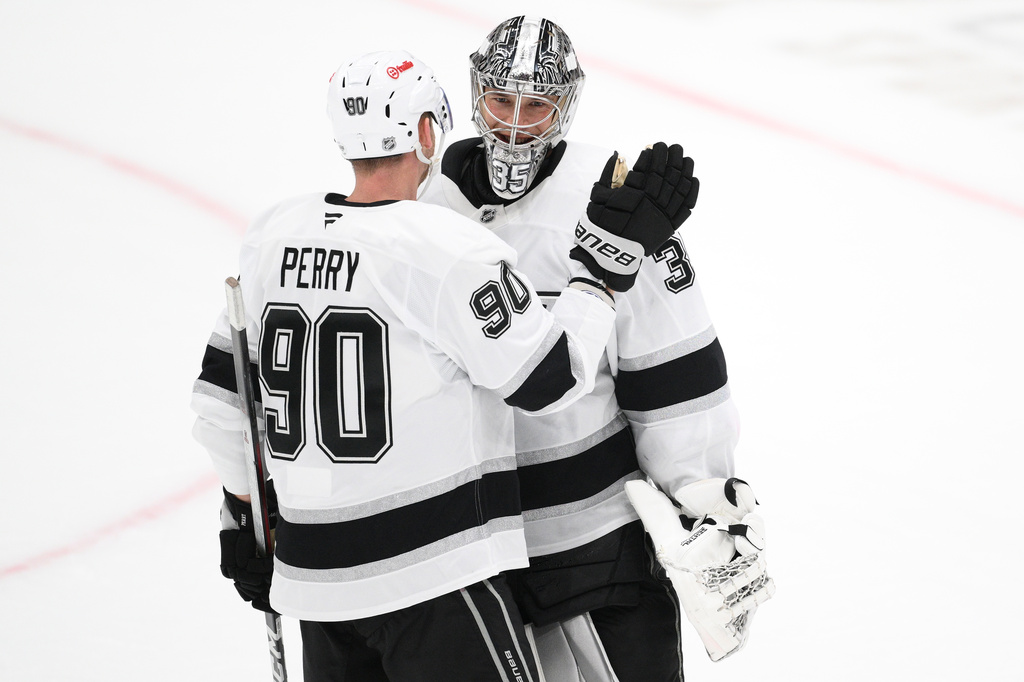 Los Angeles Kings goaltender Darcy Kuemper, right, celebrates with right wing Corey Perry (90) after an NHL hockey game against the Washington Capitals, Tuesday, Oct. 20, 2026, in Washington. (AP Photo/Nick Wass)