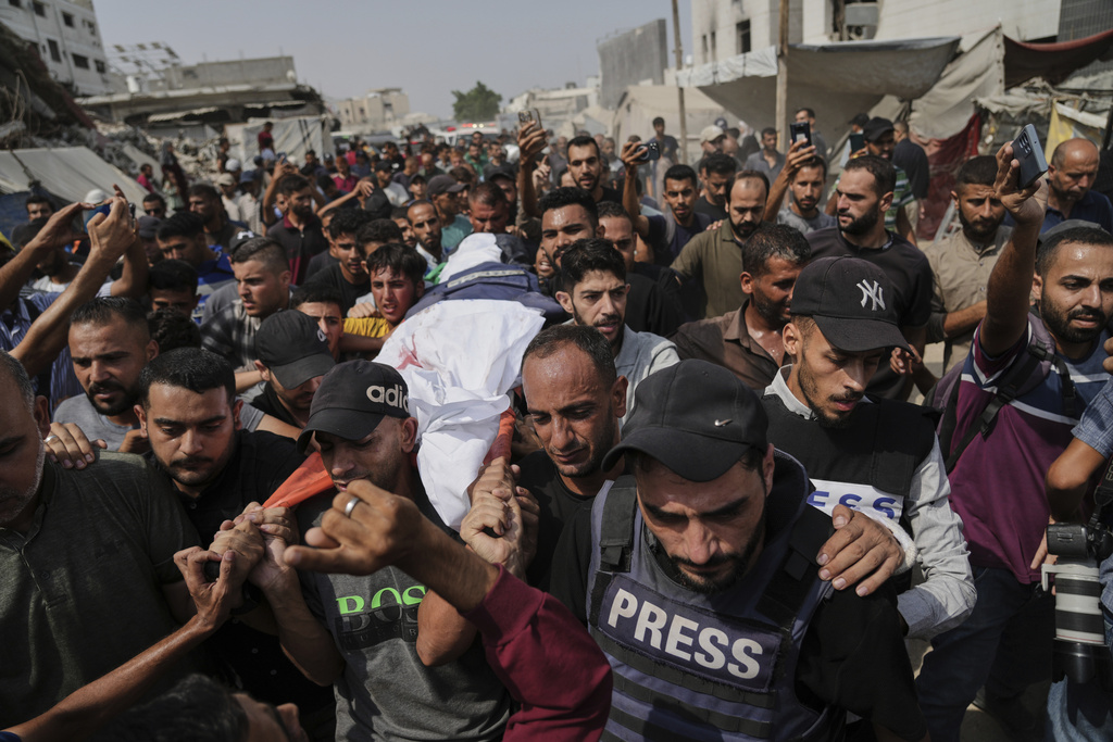 Palestinians carry the body of Al Jazeera correspondent Anas al-Sharif, who, along with other journalists, was killed in an Israeli airstrike, during his funeral outside Gaza City's Shifa hospital complex, Monday, Aug. 11, 2025. (AP Photo/Jehad Alshrafi)
