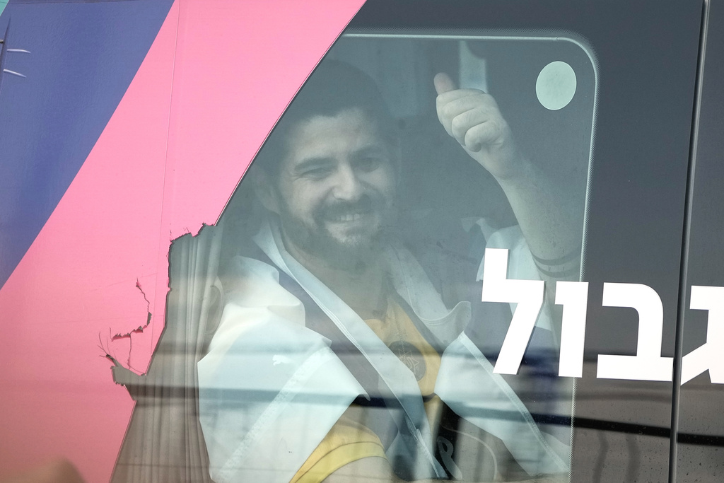 Ziv Berman, an Israeli hostage released from the Gaza Strip gestures from a minibus at the Sheba Medical Center in Ramat Gan, Israel, Monday, Oct. 13, 2025. (AP Photo/Leo Correa)