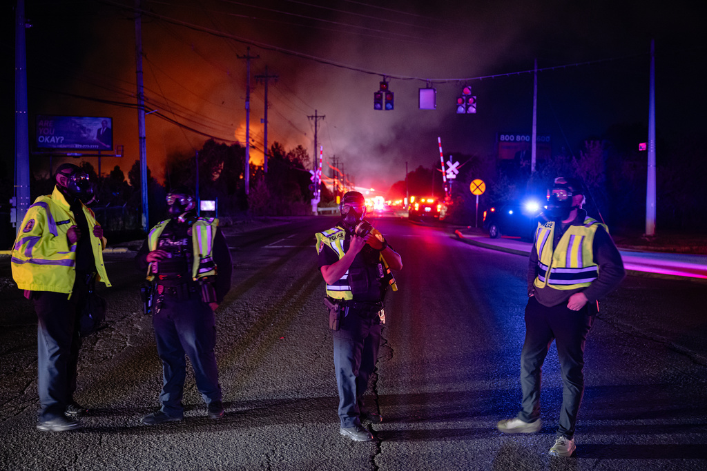 Members of law enforcement wear respirators near the area of the reported plane crash at Louisville Muhammad Ali International Airport on Tuesday, Nov. 4, 2025, in Louisville, Ky. (AP Photo/Jon Cherry)