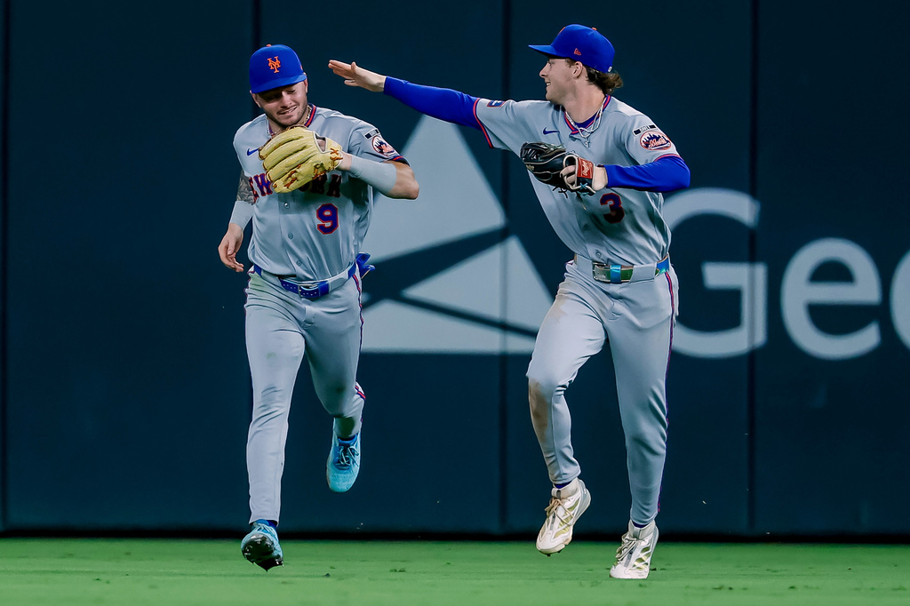 New York Mets center fielder A.J. Ewing (9) is congratulated by right fielder Carson Benge (3) after Ewing caught a sharp fly ball from Atlanta Braves' Ronald Acuña Jr. to end the eighth inning of a baseball game, Monday, Aug. 10, 2026, in Atlanta. (AP Photo/Erik S. Lesser)