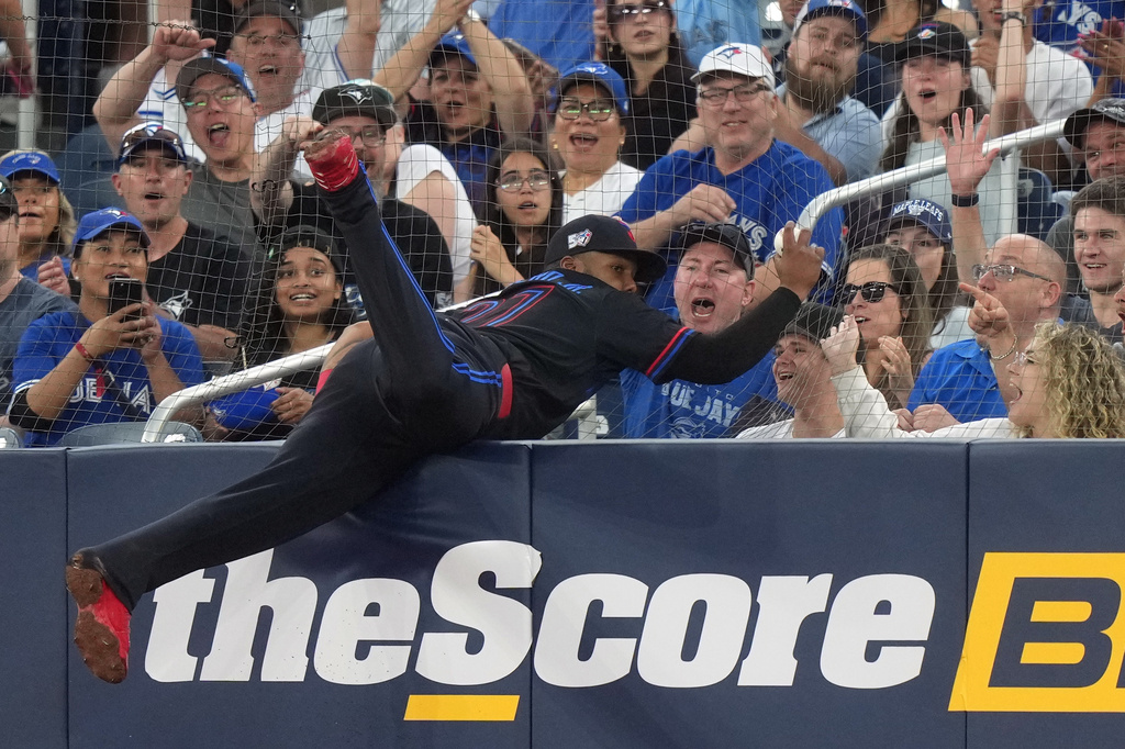 Toronto Blue Jays first baseman Vladimir Guerrero Jr., center, makes a barehanded catch during fifth-inning baseball game action against the Baltimore Orioles in Toronto, Friday, June 5, 2026. (Nathan Denette/The Canadian Press via AP)