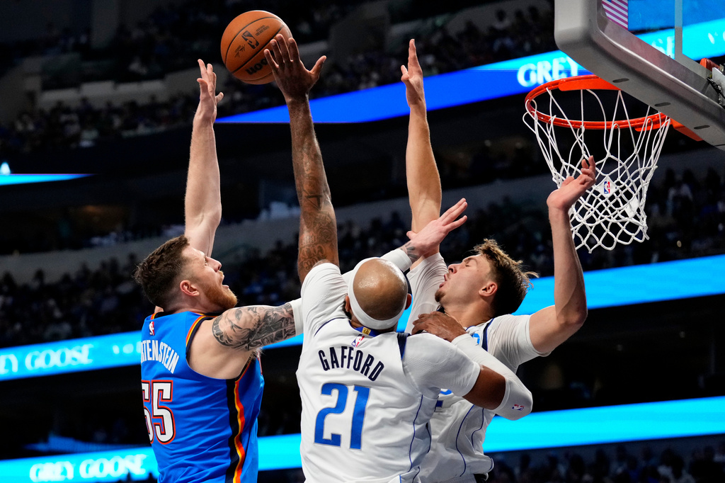Oklahoma City Thunder center Isaiah Hartenstein (55) shoots over Dallas Mavericks forward Daniel Gafford (21) and forward Cooper Flagg during the first half of an NBA basketball game Wednesday, Oct. 28, 2026, in Dallas. (AP Photo/Jeffrey McWhorter)