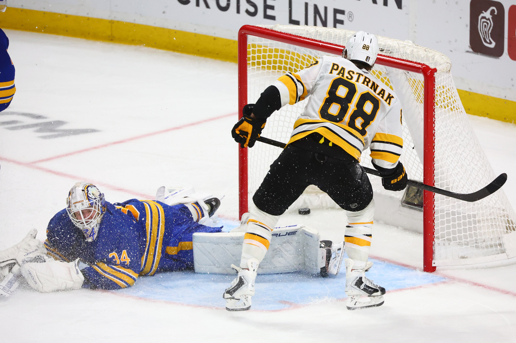 Boston Bruins right wing David Pastrnak (88) puts the puck past Buffalo Sabres goaltender Alex Lyon (34) during the overtime period in Game 5 of a first-round NHL hockey Stanley Cup playoff series Tuesday, April 28, 2026, in Buffalo, N.Y. (AP Photo/Jeffrey T. Barnes)