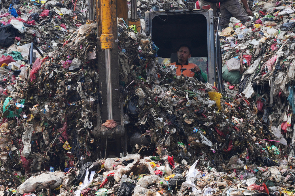 A worker operates heavy machines at the Bantargebang landfill on the outskirts of Jakarta, Indonesia, Monday, July 6, 2026. (AP Photo/Tatan Syuflana)