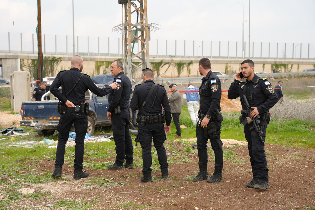 In this photo released by Israel Police on Friday, Dec. 26, 2025, Israeli police officers work on the site where a vehicle was used, according to the authorities, during a suspected ramming and stabbing attack in Afula, northern Israel. (Israel Police via AP)