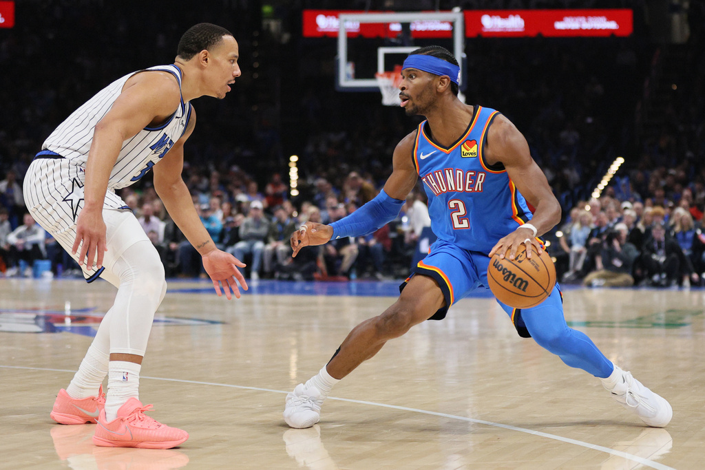 Oklahoma City Thunder guard Shai Gilgeous-Alexander (2) handles the ball against Orlando Magic guard Desmond Bane, left, during the second half of an NBA basketball game Tuesday, Feb. 3, 2026, in Oklahoma City. (AP Photo/Nate Billings)