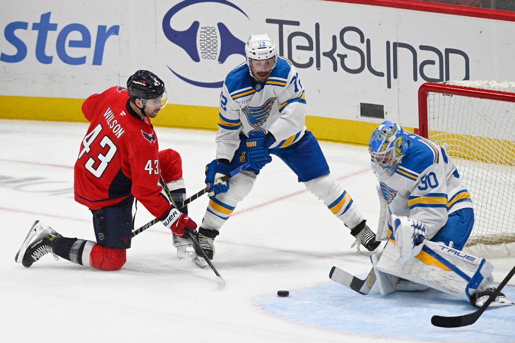 Washington Capitals right wing Tom Wilson (43) scores on St. Louis Blues defenseman Justin Faulk (72) and goaltender Joel Hofer (30) during the second period of an NHL hockey game, Wednesday, Nov. 5, 2025, in Washington. (AP Photo/John McDonnell)