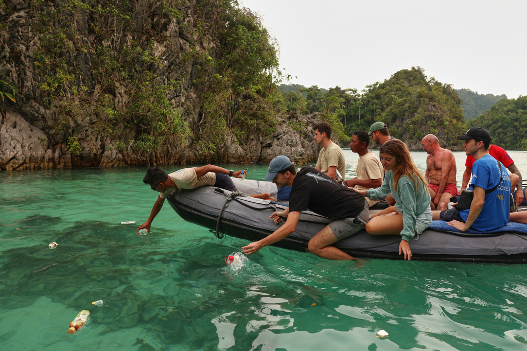 Tourists collect plastic waste from the ocean in Misool, Raja Ampat, Indonesia, Monday, March 2, 2026. (AP Photo/Claudia Rosel)