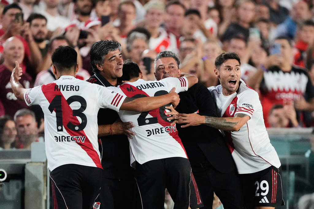 River Plate coach Marcelo Gallardo, second from right, is embraced by player Lucas Martínez Quarta after he scored his side's first goal against Banfield, during an Argentine soccer league match, Gallardo's last as manager, in Buenos Aires, Argentina, Thursday, Feb. 26, 2026. (AP Photo/Gustavo Garello)