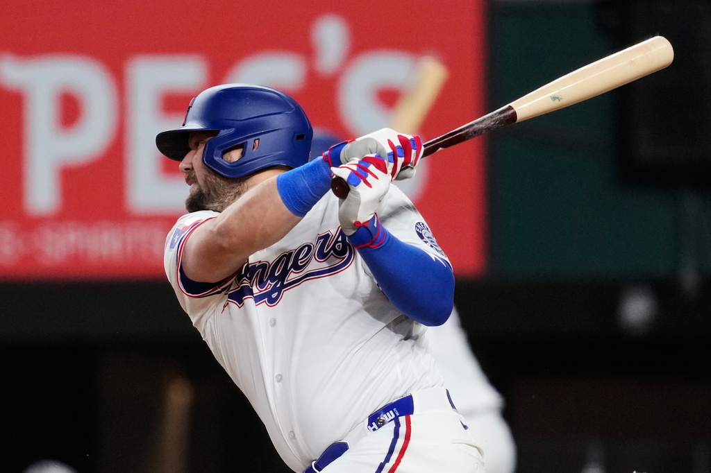 Texas Rangers' Jake Burger connects for a run-scoring single to right in the fifth inning of a baseball game against the Arizona Diamondbacks Tuesday, May 12, 2026, in Arlington, Texas. (AP Photo/Tony Gutierrez)