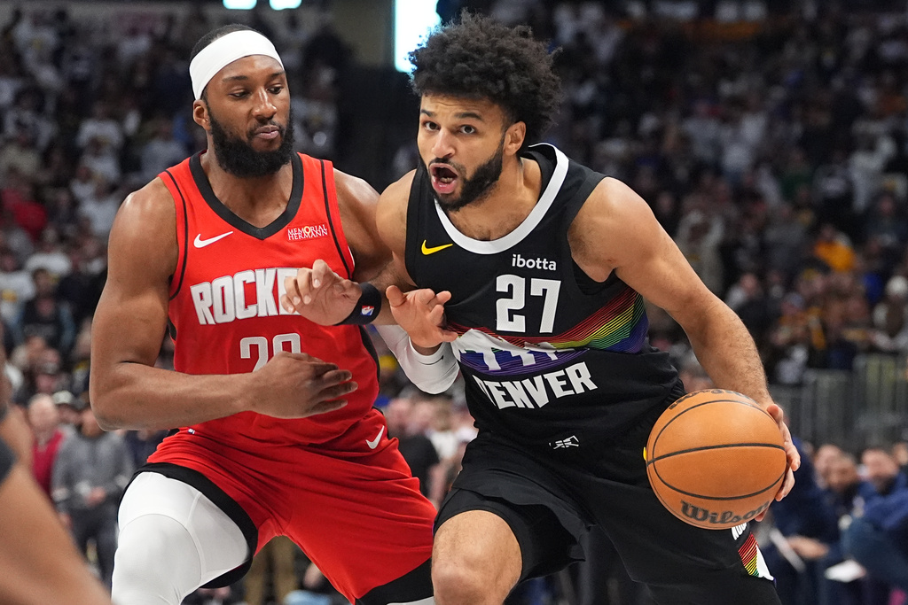 Denver Nuggets guard Jamal Murray, right, drives past Houston Rockets guard Josh Okogie, left, in the first half of an NBA basketball game Saturday, Dec. 20, 2025, in Denver. (AP Photo/David Zalubowski)