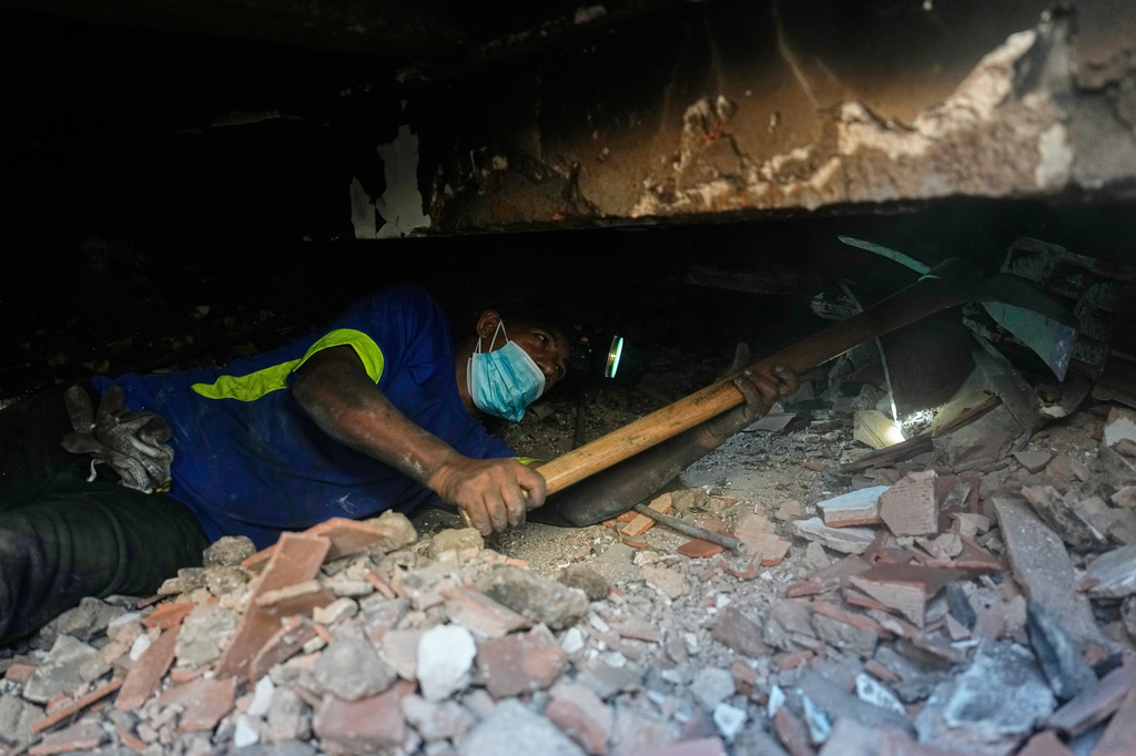 Franklin Rodriguez searches for missing relatives in the rubble of his apartment building, which collapsed in the back-to-back earthquakes that struck La Guaira, Venezuela, Monday, June 29, 2026. (AP Photo/Fernando Vergara)