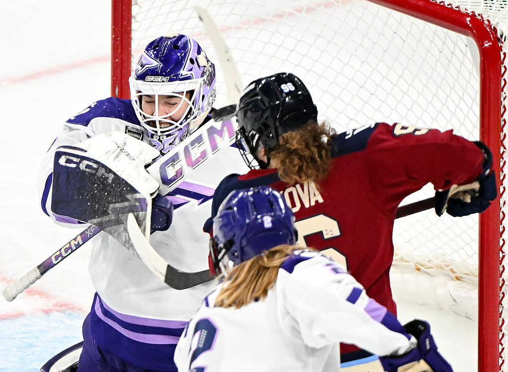 Minnesota Frost goaltender Maddie Rooney, left, swats the puck away from Montreal Victoire's Natalie Mlynkova (96) during second-period PWHL hockey game action in Laval, Quebec, Sunday, Jan. 4, 2026. (Graham Hughes/The Canadian Press via AP)