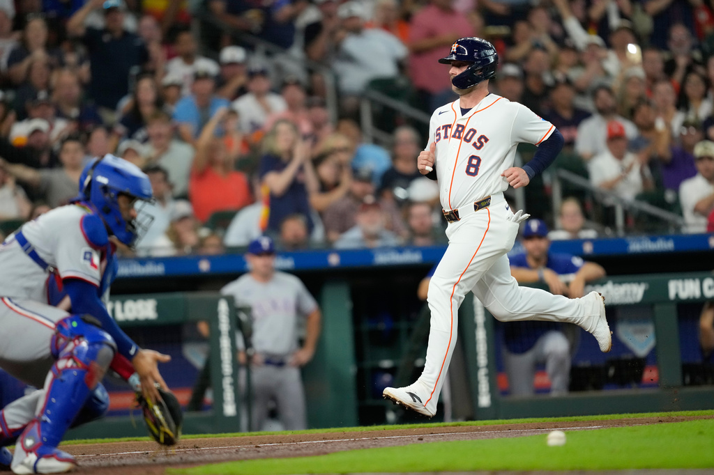 Houston Astros' Christian Walker (8) scores as Texas Rangers catcher Elias Díaz handles the throw during the third inning of a baseball game Saturday, Aug. 1, 2026, in Houston. (AP Photo/David J. Phillip)