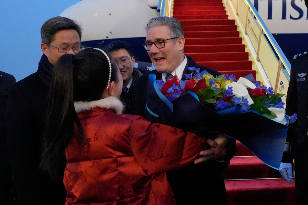 Britain's Prime Minister Keir Starmer receives a bouquet of flowers at an airport in Beijing, China, Wednesday, Jan. 28, 2026. (AP Photo/Kin Cheung, Pool)