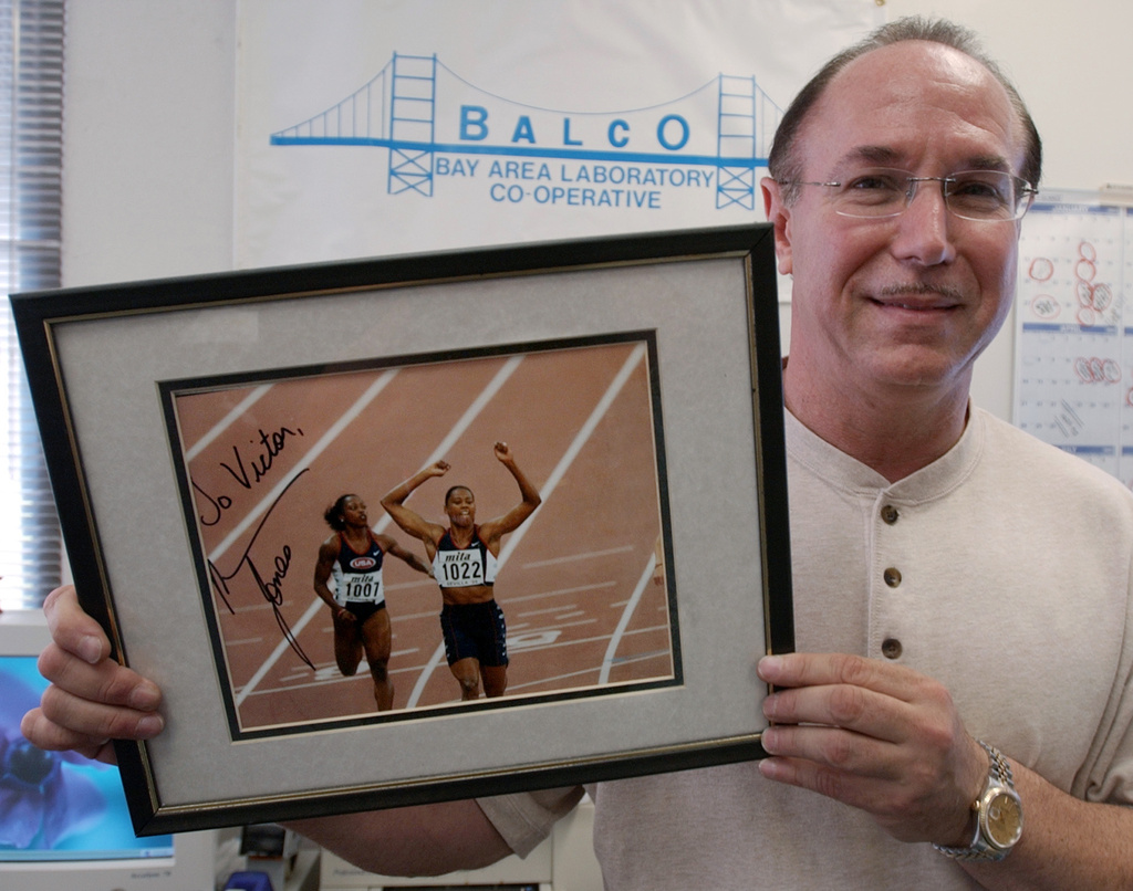 FILE - BALCO founder Victor Conte holds up an autographed photo addressed to Conte of track star Marion Jones in his office in Burlingame, Calif., Oct. 21, 2003. (AP Photo/Paul Sakuma, File)