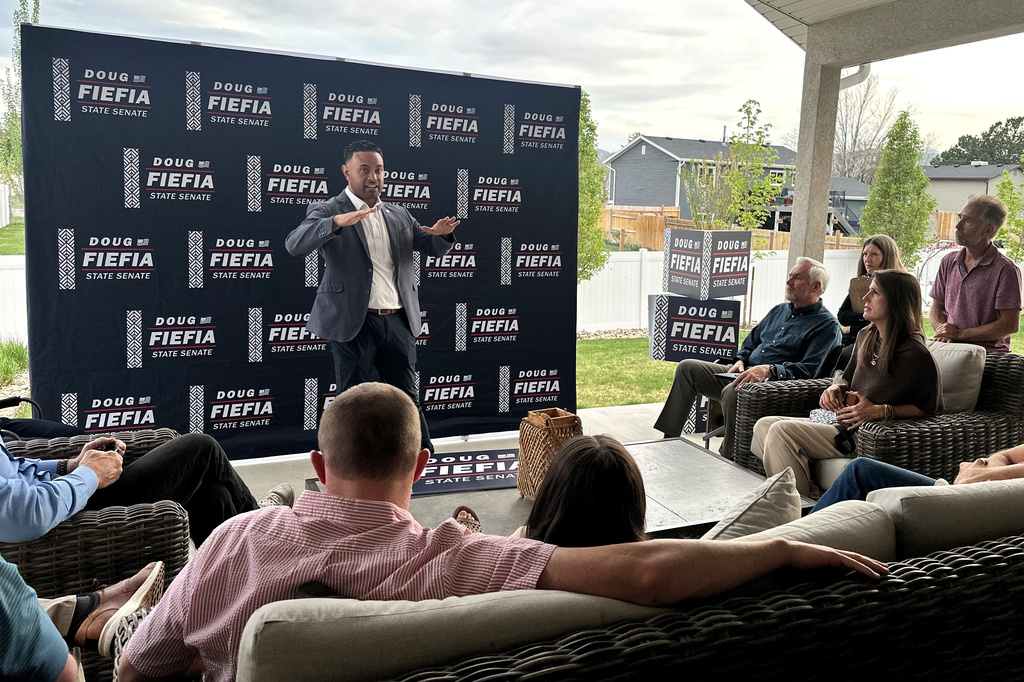 Utah State Rep. Doug Fiefia talks to Utah voters on the back deck of a house, Thursday, April 9, 2026, in Riverton, Utah. Fiefia, a Republican, has a background in technology and is running for the state senate with a pledge to tackle AI. (AP Photo/Nicholas Riccardi)