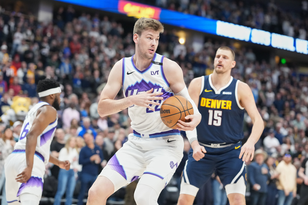 Utah Jazz center Kyle Filipowski, front, pulls in a rebound in front of Denver Nuggets center Nikola Jokić (15) in the first half of an NBA basketball game Friday, March 27, 2026, in Denver. (AP Photo/David Zalubowski)