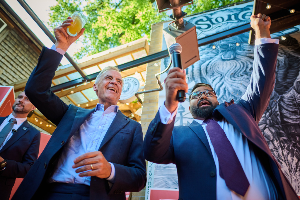 Canadian Prime Minister Mark Carney, left, and Liberal Party Beaches-East York by-election candidate Tanveer Shahnawaz cheer with supporters at The Stone Lion Pub in Toronto, on Wednesday, Aug. 5, 2026. (Sammy Kogan/The Canadian Press via AP)