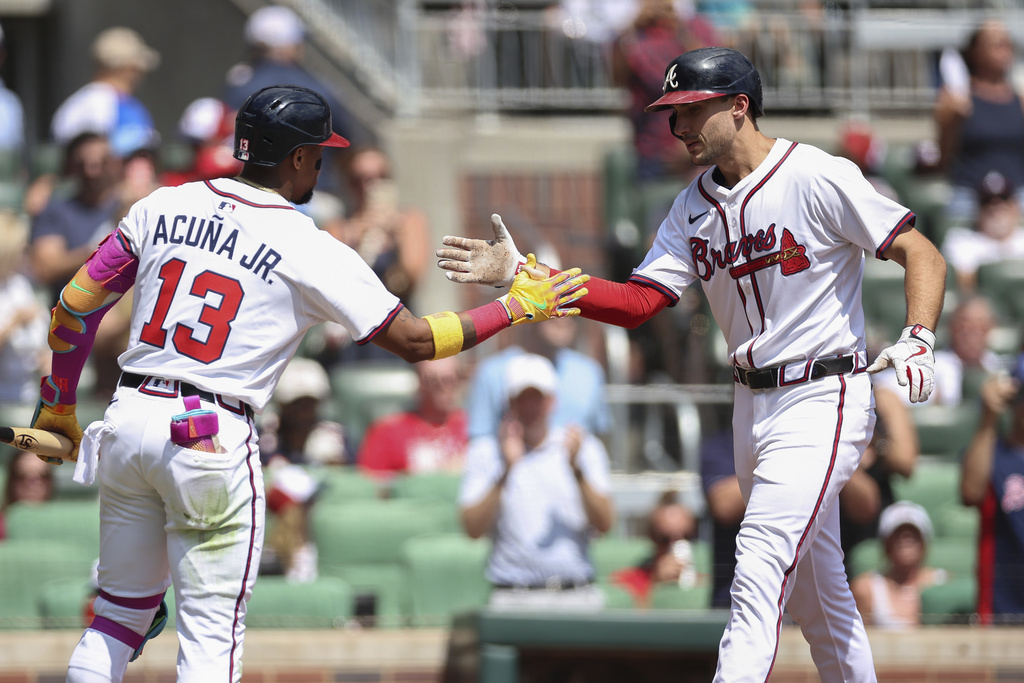 Atlanta Braves' Ronald Acuña Jr. (13) high-fives Matt Olson, right, after Olson's solo home run in the first inning of a baseball game against the Houston Astros, Sunday, Sept. 14, 2025, in Atlanta. (AP Photo/Colin Hubbard)