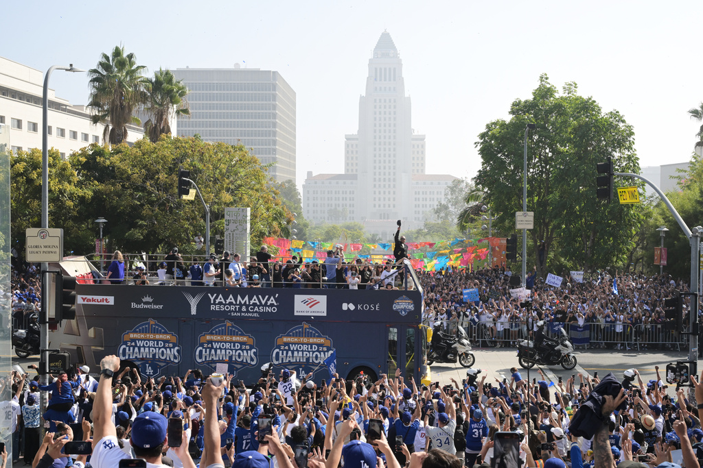 Los Angeles Dodgers players, family and staff ride on top of double-decker buses during a parade to celebrate the baseball team's World Series win on Monday, Nov. 3, 2025, in Los Angeles. (AP Photo/Kyusung Gong)