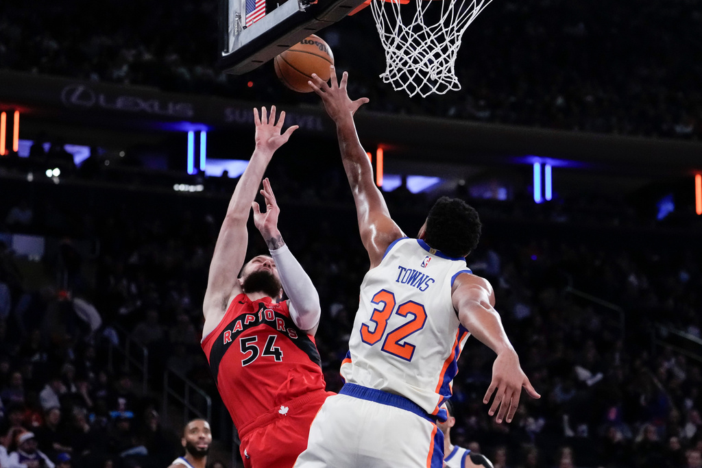 Toronto Raptors forward Sandro Mamukelashvili (54) shoots over New York Knicks center Karl-Anthony Towns (32) during the first half of an NBA basketball game, Sunday, Nov. 30, 2025, in New York. (AP Photo/Yuki Iwamura)