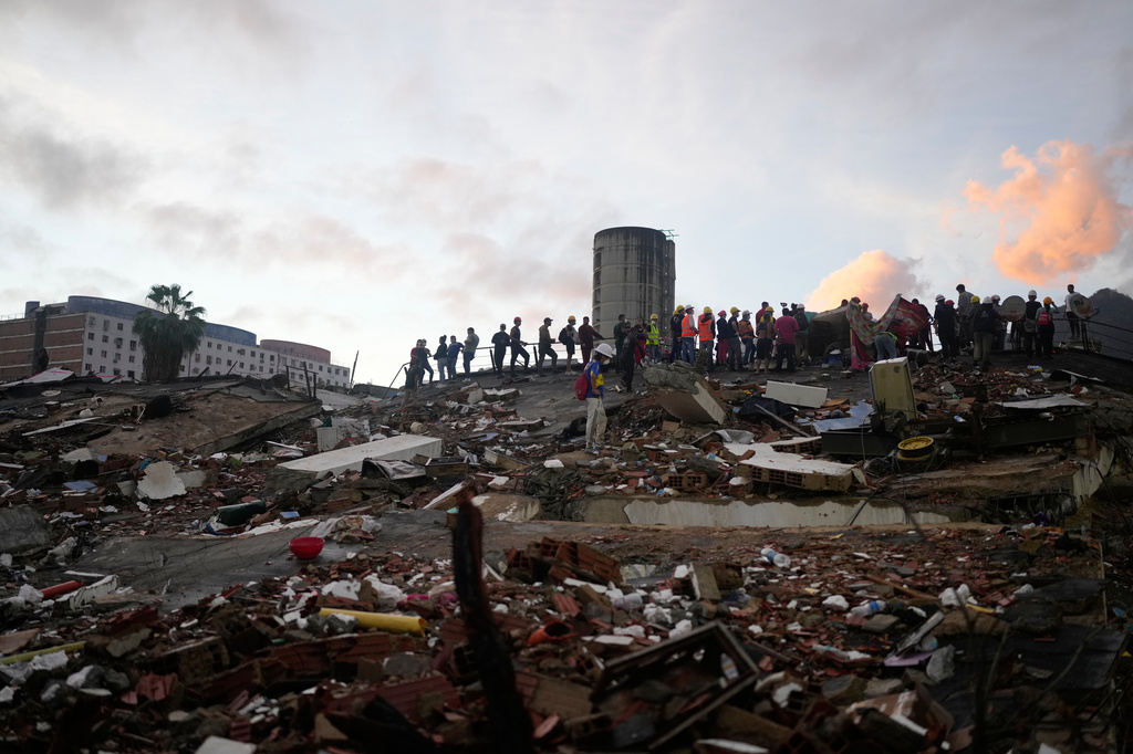 Rescuers search through the rubble of buildings that collapsed in the earthquakes in La Guaira, Venezuela, Tuesday, June 30, 2026. (AP Photo/Ariana Cubillos)