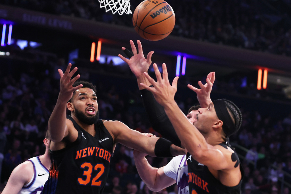 New York Knicks center Karl-Anthony Towns (32) and teammate Josh Hart, right, reach up for the ball during the first half of an NBA basketball game against the Utah Jazz, Friday, Dec. 5, 2025, in New York. (AP Photo/Heather Khalifa)