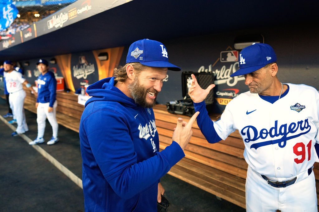Los Angeles Dodgers pitcher Clayton Kershaw and third base coach Dino Ebel get ready for Game 4 of baseball's World Series against the Toronto Blue Jays, Tuesday, Oct. 28, 2025, in Los Angeles. (AP Photo/Brynn Anderson)