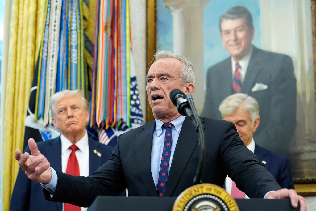 Secretary of Health and Human Services Robert F. Kennedy, Jr., speaks in the Oval Office of the White House, Tuesday, Sept. 30, 2025, in Washington, as President Donald Trump, left, and Mehmet Oz, Administrator for the Centers for Medicare & Medicaid Services, look on. (AP Photo/Alex Brandon)
