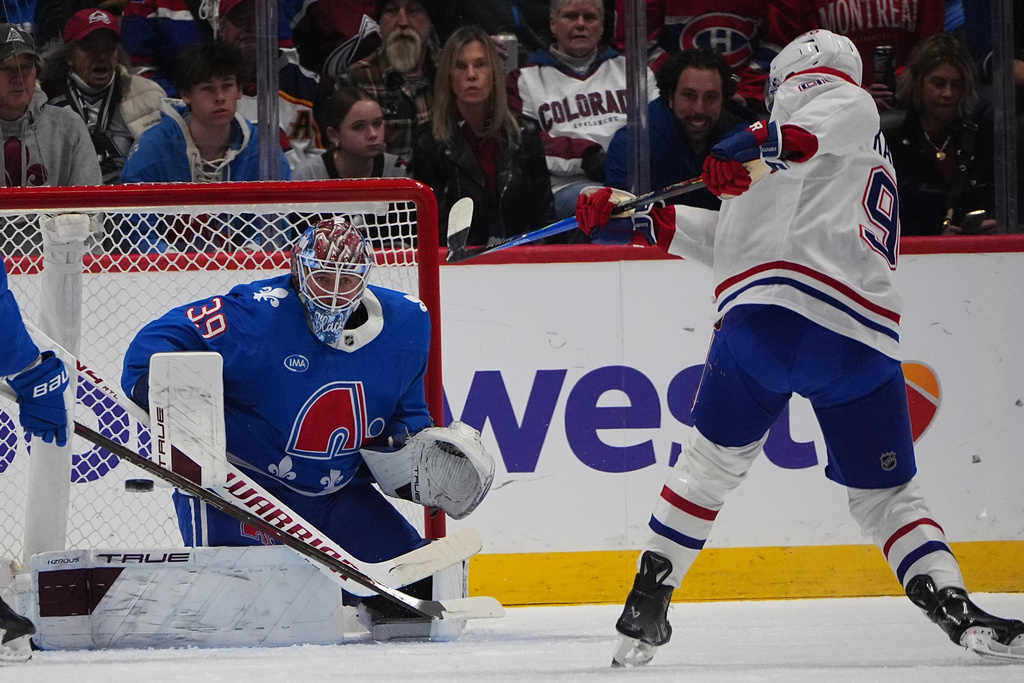 Montreal Canadiens center Oliver Kapanen, right, shoots the puck at Colorado Avalanche goaltender Mackenzie Blackwood in the first period of an NHL hockey game Saturday, Nov. 29, 2025, in Denver. (AP Photo/David Zalubowski)