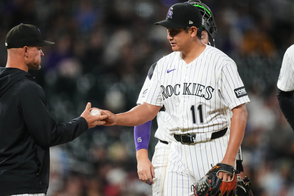 Colorado Rockies manager Warren Schaeffer, left, takes the ball from starting pitcher Tomoyuki Sugano as he is pulled from the mound after giving up a single to San Diego Padres' Xander Bogaerts in the sixth inning of a baseball game Wednesday, April 22, 2026, in Denver. (AP Photo/David Zalubowski)