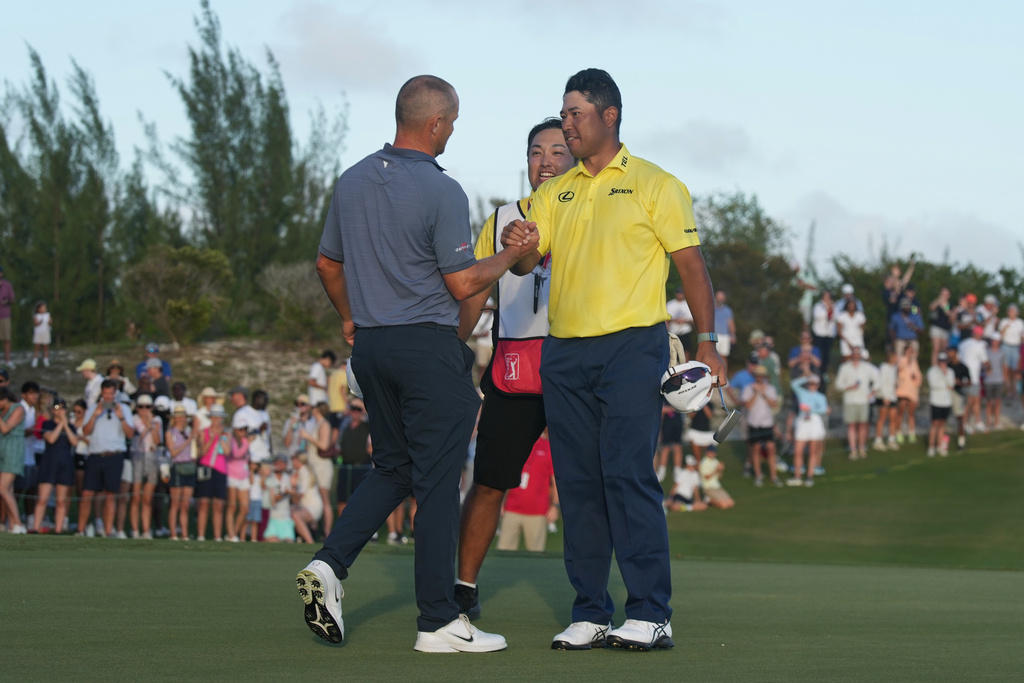 Hideki Matsuyama, of Japan, shakes hands with Alex Noren, of Sweden, left, after winning the Hero World Challenge PGA Tour at the Albany Golf Club, in New Providence, Bahamas, Sunday, Dec. 7, 2025. (AP Photo/Fernando Llano)