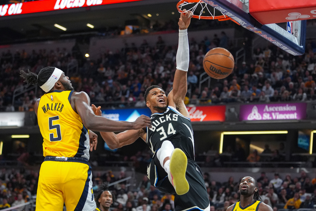 Milwaukee Bucks forward Giannis Antetokounmpo (34) gets a basket on a dunk in front of Indiana Pacers forward Jarace Walker (5) during the first half of an NBA basketball game in Indianapolis, Monday, Nov. 3, 2025. (AP Photo/Michael Conroy)