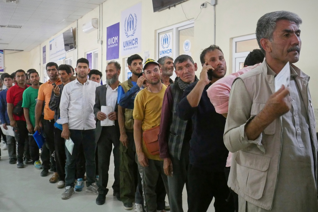 FILE - Afghan refugees who returned after fleeing Iran to escape deportation and conflict line up at a UNHCR facility near the Islam Qala crossing in western Herat province, Afghanistan, June 20, 2025. (AP Photo/Omid Haqjoo, file)