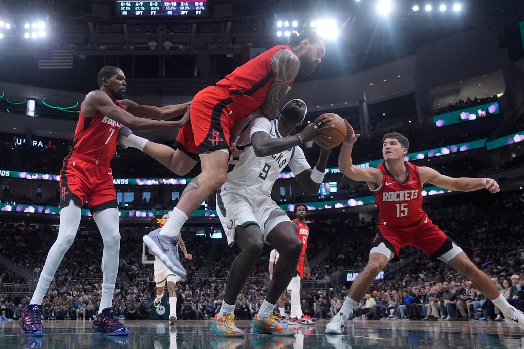 Houston Rockets' Steven Adams fouls Milwaukee Bucks' Bobby Portis during the first half of an NBA basketball game Sunday, Nov. 9, 2025, in Milwaukee. (AP Photo/Morry Gash)