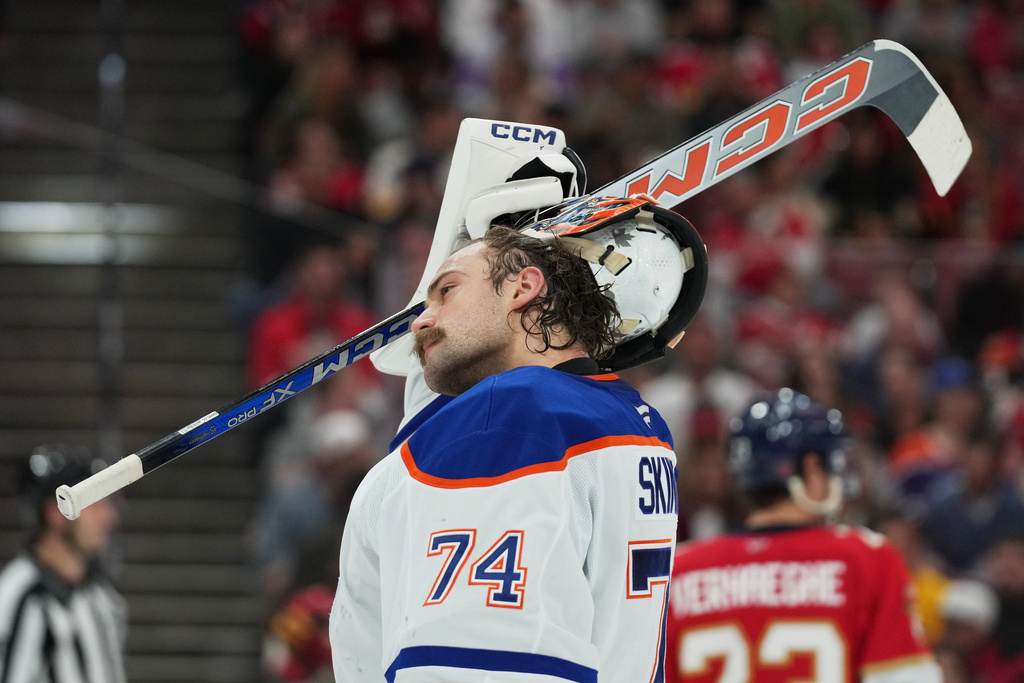 Edmonton Oilers goaltender Stuart Skinner (74) adjust his helmet during the second period of an NHL hockey game against the Florida Panthers, Saturday, Nov. 22, 2025, in Sunrise, Fla. (AP Photo/Lynne Sladky)