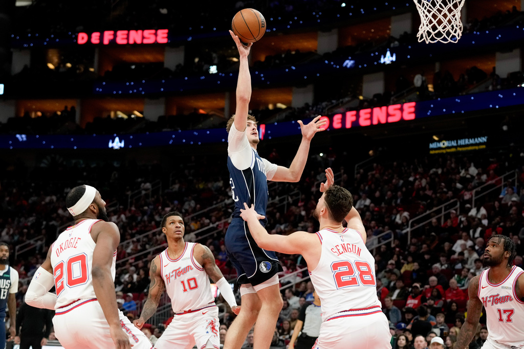 Dallas Mavericks forward Cooper Flagg, center, shoots as Houston Rockets center Alperen Sengun (28) defends during the first half of an NBA basketball game Saturday, Jan. 31, 2026, in Houston. (AP Photo/Eric Christian Smith)