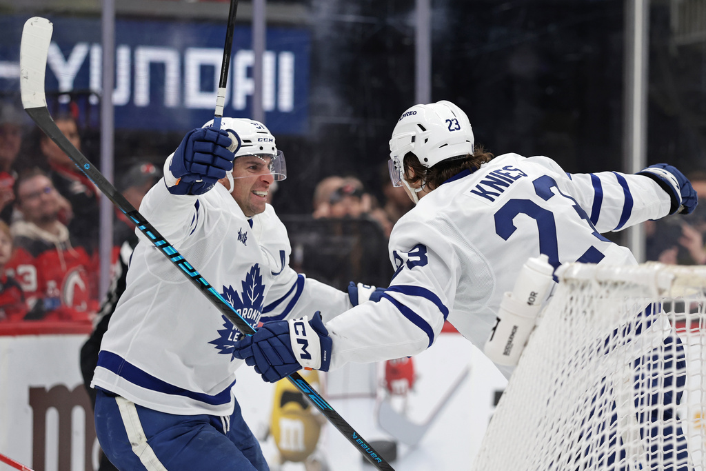 Toronto Maple Leafs left wing Matthew Knies (23) is congratulated by center John Tavares (91) after scoring a goal during the third period of an NHL hockey game against the New Jersey Devils, Wednesday, March 4, 2026, in Newark, N.J. (AP Photo/Adam Hunger)