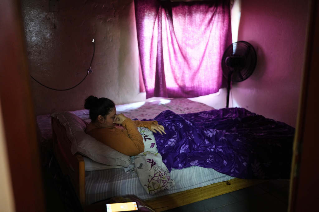 Analia Noemi Celis, who has cerebral palsy, lays on her bed at her home in Moreno, on the outskirts of Buenos Aires, Argentina Wednesday, May 13, 2026. (AP Photo/Natacha Pisarenko)